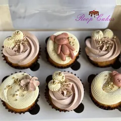 A box of teddy bear themed cupcakes, perfect for a baby's first celebration. I used a mix of delicate frosting swirls with golden sprinkles and handcrafted fondant teddy bears for a cute and classy look.