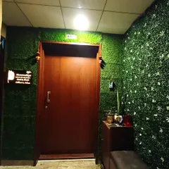A full view of the apartment entrance makeover. The artificial grass walls surround the main door, making the entryway feel cozy and distinct from the rest of the building.