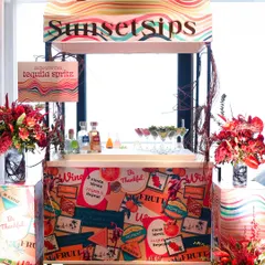 A custom "Sunset Sips" bar for a Mexican-themed party. We can arrange full bar services, including themed cocktail stations like this "make your own tequila spritz" cart, to perfectly complement your menu and event vibe.