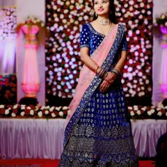 This royal blue velvet lehenga with intricate silver embroidery is a showstopper. Paired with a contrasting pink dupatta, it's a beautiful rental choice for a wedding reception or sangeet.