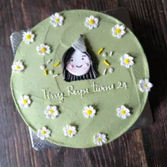 This larger cake showcases a cute and simple bento-style design. It features a hand-drawn portrait for the birthday girl, surrounded by a field of sweet, simple daisies.