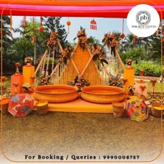 This outdoor Haldi setup features large traditional urlis for the ceremony, set against a geometric backdrop made of marigold strings. We used colorful Rajasthani umbrellas and floral arrangements to create a festive, rustic atmosphere.