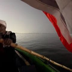 A boat ride on the Sangam at dusk during the Mahakumbh. The vastness of the water and the distant lights of the camp create a surreal and meditative atmosphere.