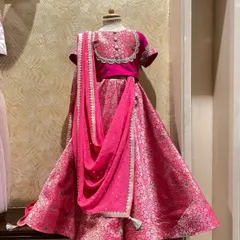 A client brought me this beautiful pink brocade fabric, and I transformed it into this regal lehenga for her daughter. The design features a unique neckline and a draped dupatta for a sophisticated look.