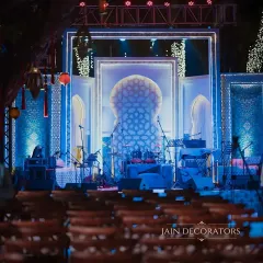 A sangeet stage that is both luminous and artistic. The backdrop features intricate geometric patterns inspired by Turkish design, lit from within to create a mesmerizing effect for the musical night.