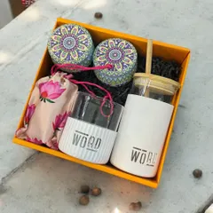 This corporate gift set for 'WORD' features a branded borosilicate glass and sipper, along with decorative tins, presented in a vibrant yellow box. It's a great example of practical and eye-catching branding.