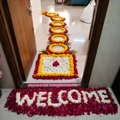 A welcoming floral arrangement at the doorstep. We used fresh rose and jasmine petals to write the word 'Welcome', followed by a traditional floral rangoli pathway to greet guests.