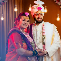 A classic portrait of the happy couple, Mrunal and Prachiti, in their traditional Marathi wedding attire, complete with the mundavalya and turban.