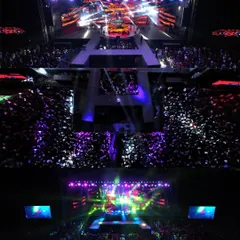 An aerial top-down shot capturing the immense crowd and spectacular stage lighting at Acharya Habba 2024. This perspective, only possible with professional drone videography, shows the sheer scale of the event and the energy of the audience.