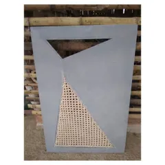 A finished panel combining a modern, geometric grey surface with a triangular, handwoven cane insert. This piece, designed for a cabinet shutter, blends contemporary design with traditional, natural materials for a fresh, retro feel.