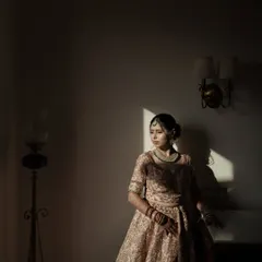 An artistic bridal portrait using shadows and light. The bride stands in a sliver of sunlight, creating a dramatic and contemplative mood that is absolutely captivating.