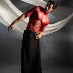 This conceptual shoot involved applying vibrant red body paint to create a powerful, statuesque look. I used slicked-back hair to keep the focus on the defined musculature and the stark contrast between the red paint and the dark draping.