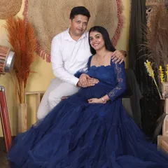 A beautiful couple's portrait from a glamorous studio session. The partner’s embrace adds a sense of warmth and support, perfectly complementing the elegance of the maternity gown.