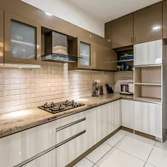 A sophisticated two-tone kitchen with glossy brown upper cabinets and off-white lower units. The design includes frosted glass sections and a tall unit for appliances, creating a practical and elegant cooking space.