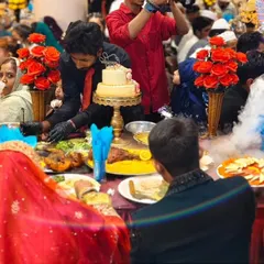 A close-up of the bride and groom's table, adorned with floral arrangements, a tiered cake, and our spectacular food presentation.
