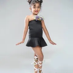 A full-body shot from a creative kids' portrait session. The styling with flowers and ribbons adds a touch of whimsy, while the confident pose is perfect for a young performer's portfolio.