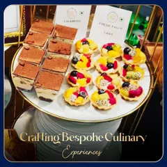 A platter of classic desserts: individual portions of rich Tiramisu and colorful Fresh Fruit Tarts. These are perfect, single-serving options for corporate events.
