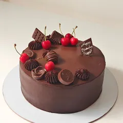 A classic and decadent chocolate truffle cake, topped with fresh cherries and a variety of chocolate garnishes. A timeless choice for any celebration.