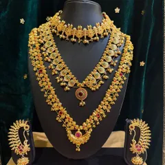 A beautiful gold-finish jewellery set with intricate detailing, perfect for pairing with a traditional silk saree or lehenga.