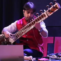 A focused moment during my TEDx talk, using technology to help illustrate the concepts of raag and taal. I blend traditional teaching with modern tools to make learning more effective.