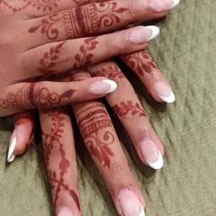 A classic French manicure is always a beautiful choice, especially for a wedding. Here, the clean white tips on long almond-shaped nails look so elegant against the intricate mehendi design.