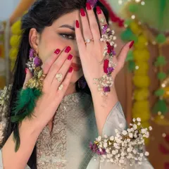 A playful shot showing off the details of the floral jewelry and the bright red nails, which add another pop of color to the overall Haldi look.