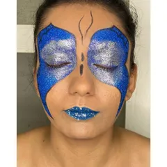With eyes closed, you can see the full effect of the glitter butterfly wings. This demonstrates the complete artistry involved in creating symmetrical and impactful editorial makeup.