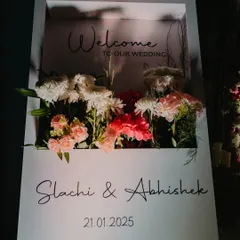 A modern and chic welcome sign with a 3D floral element, elegantly displaying the couple's names and wedding date.