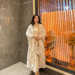 A full-length shot of the white Anarkali, showing the beautiful drape and intricate gold embroidery.