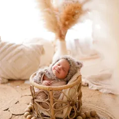 This little bear is fast asleep. Using natural textures like this woven basket and a fuzzy bonnet creates a warm, organic feel for your newborn's first portraits.