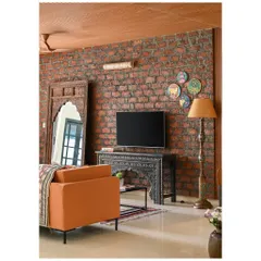 This 4BHK apartment in Goa was designed to blend traditional craftsmanship with modern living. The family lounge features an exposed brick wall, a carved console, and a large arched mirror to create an eclectic, inviting feel.