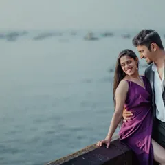 A happy, candid moment by the Mumbai waterfront. The sea and the distant boats provide a classic urban backdrop for a relaxed and romantic pre-wedding portrait.