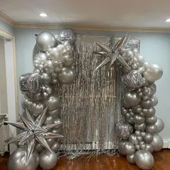 Looking for a fun and flashy backdrop? This silver-themed setup is perfect for disco nights, New Year's parties, or bachelorettes. It features a metallic fringe curtain, star-shaped foil balloons, and a full arch of silver balloons.