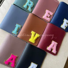 Travel with a pop of personality. These passport covers come in a variety of colors and are adorned with fluffy chenille patch initials, making them a fun and stylish accessory for any globetrotter.