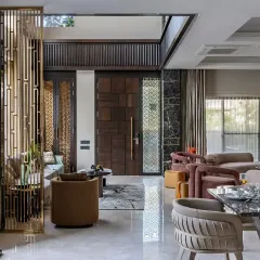 A closer look at the entrance of this living space, where a custom wooden door and intricate metal screen set a luxurious tone. The design ensures that every element, from the entrance to the seating, contributes to a cohesive aesthetic.