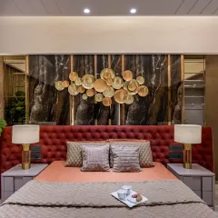 A duplicate of image 8, this image focuses on the striking combination of the red upholstered headboard and the dark marble wall, creating a luxurious and inviting ambiance.