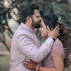A tender forehead kiss, a classic and timeless pose for an engagement shoot. The couple's coordinated pastel outfits add to the soft, romantic, and elegant feel of the portrait.