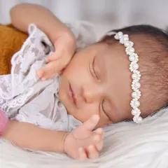 I love capturing those fleeting expressions, like this sweet, sleepy smile. This close-up portrait showcases the baby's delicate features and the soft texture of the faux fur she is resting on.