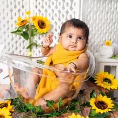 Bath time in a field of sunflowers. This fun shot is part of a six-month milestone session, adding a playful and unique element to the gallery.