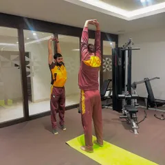 A full-body overhead stretch helps lengthen the spine and open the shoulders, which is critical for cricketers, especially bowlers and batsmen. I guide athletes through each movement to maximize its benefit.