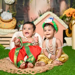 Double the fun with twin Krishnas! It can be a challenge to get two babies to smile at once, but these little ones were so cooperative. This photo captures a beautiful, happy moment from their Janmashtami shoot.