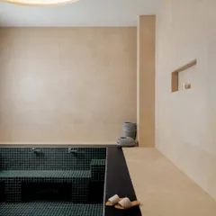 This luxury washroom feels like a private home spa. We used soft beige walls and a deep green tiled pool to create contrast and depth. The gentle, recessed lighting enhances the serene mood, turning a functional area into an experience of calm.