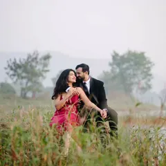 An intimate moment nestled in the tall grass by the lake. The natural elements frame the couple, making the scene feel private and romantic.