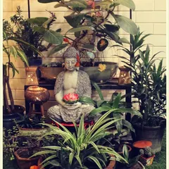 We styled this home entrance for a festive occasion by creating a lush green corner. A Buddha statue sits amongst a variety of plants, with a ring of marigold flowers adding a traditional and vibrant touch.