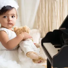 A quiet moment with a furry friend. This close-up from a sitter session highlights the beautiful, innocent expression of a baby girl holding her teddy bear.