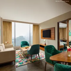 Our suites are designed to feel like a home away from home, with separate zones for relaxing and sleeping. The large windows fill the space with natural light.