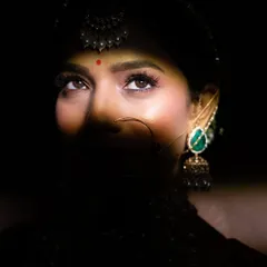 I love playing with light and shadow to create dramatic bridal portraits. This shot highlights the bride's expressive eyes and intricate jewellery, capturing her anticipation and beauty just before the main event.