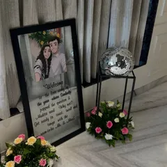 A personalized welcome sign with a caricature of the couple, placed at the entrance of a home for a pre-wedding event. It's these small details that make a celebration unique.