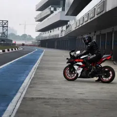 A moment of calm before the storm. A rider sits on their Apache RR 310 in the pit lane of the Buddh International Circuit, mentally preparing for their session on the track.