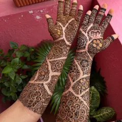 A beautiful shot of the engagement mehendi, showing the contrast between the fresh paste and the developing stain. The design features a lovely net pattern.